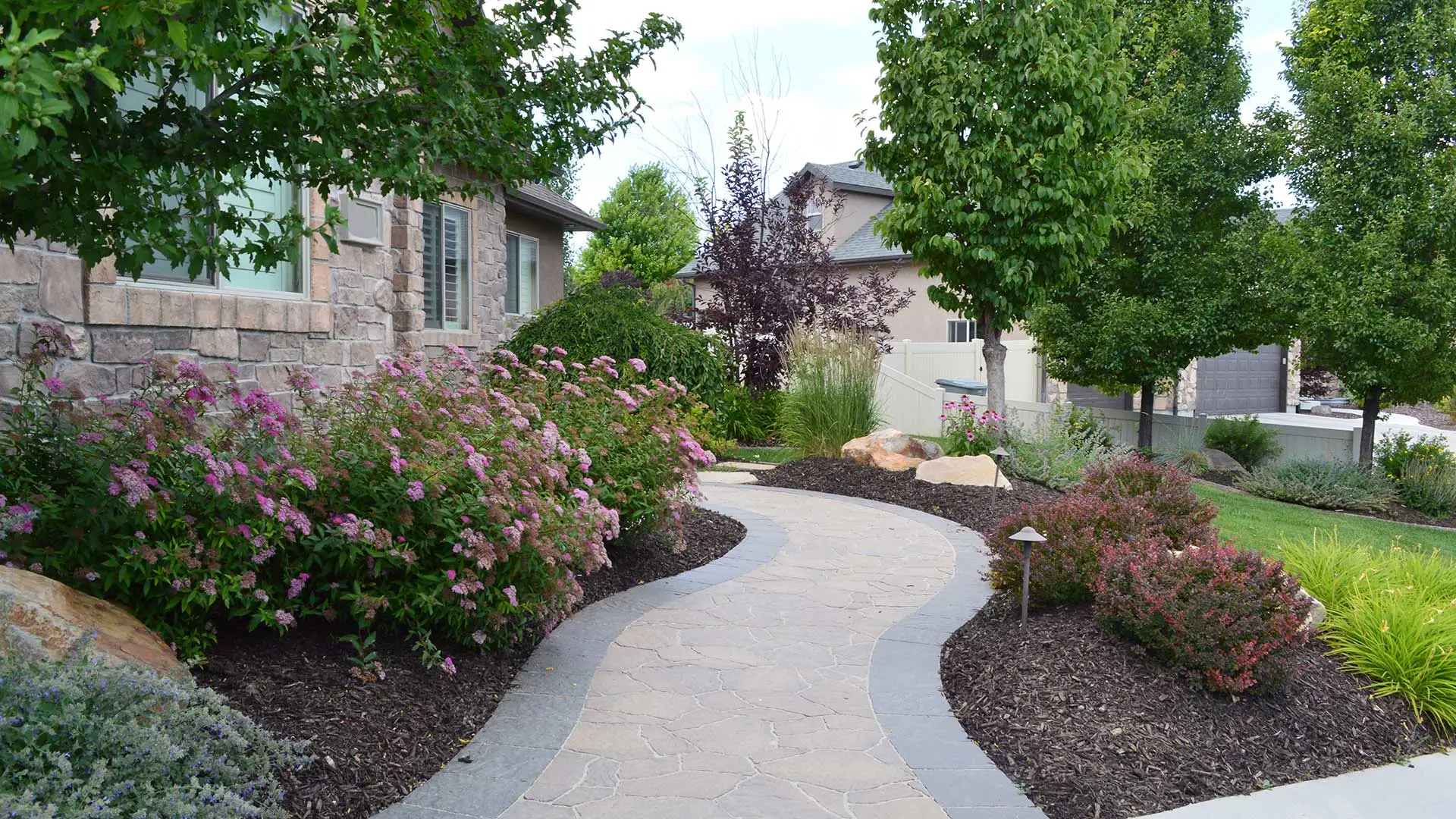 Professionally designed landscaping with mature annuals in front of a home in Salt Lake City, UT.